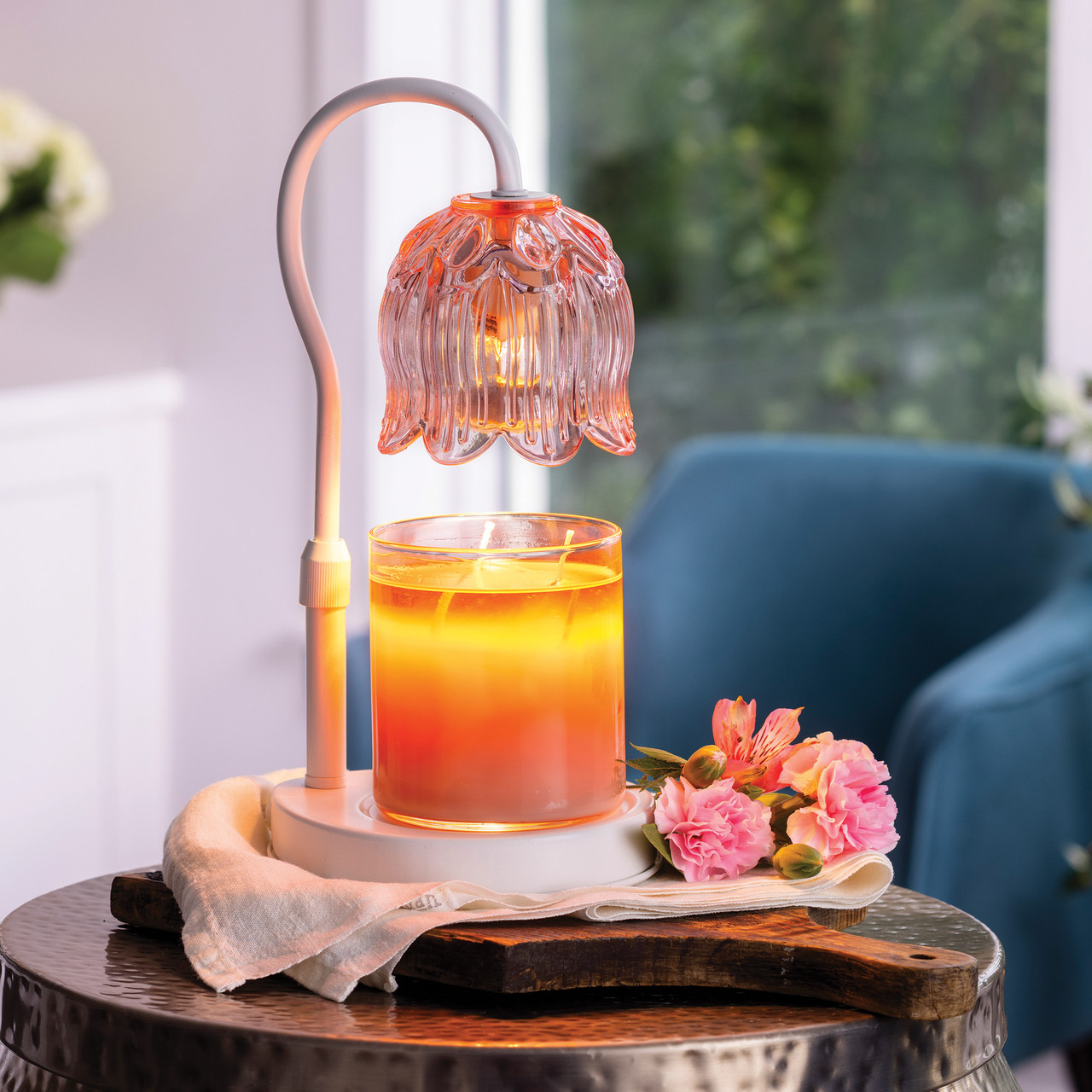 The Tulip Candle Warmer Lamp pairs a soft pink floral-shaped shade with a sleek white base for vintage-inspired elegance.